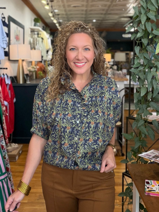 Woman wearing a patterned shirt in a store setting