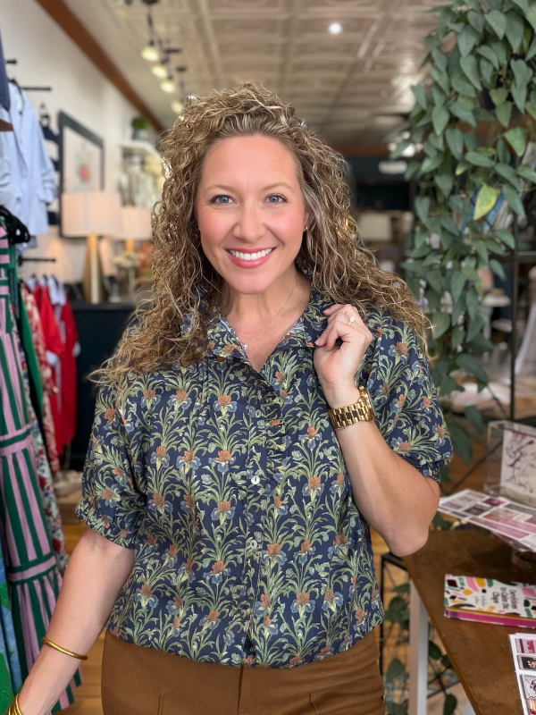 Woman wearing a patterned shirt in a store setting