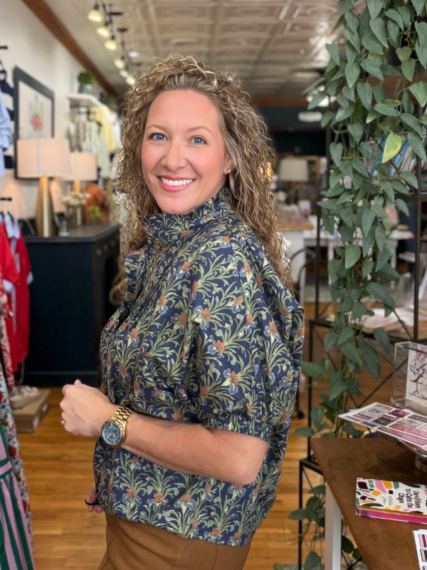 Woman wearing a floral blouse in a store setting