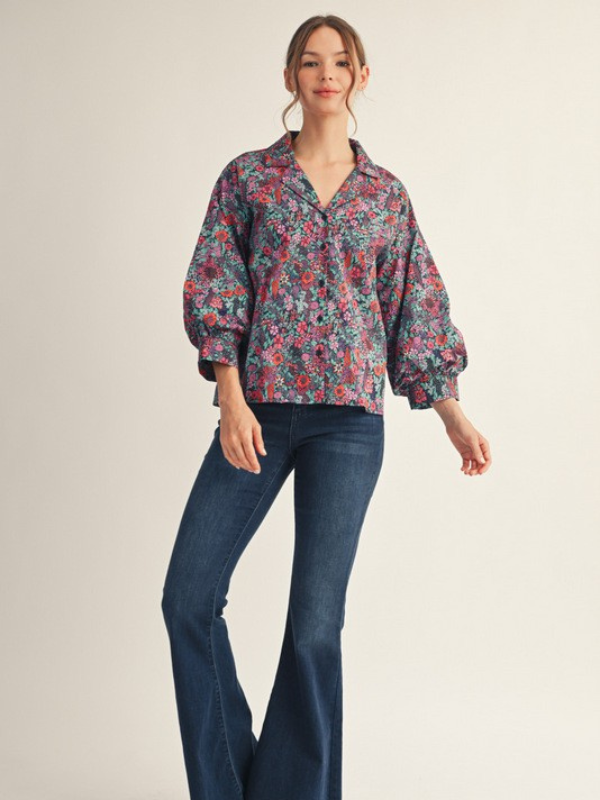Woman wearing a floral blouse and blue jeans on a beige background