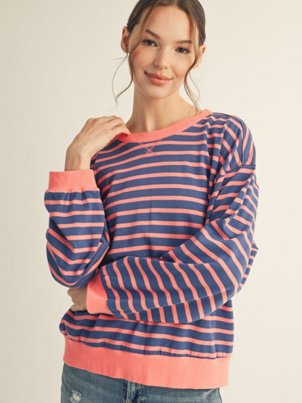 Woman wearing a blue and pink striped sweater on a beige background