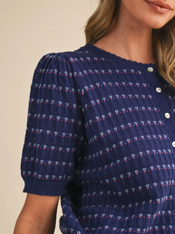 woman wearing a navy pointelle button sweater 
