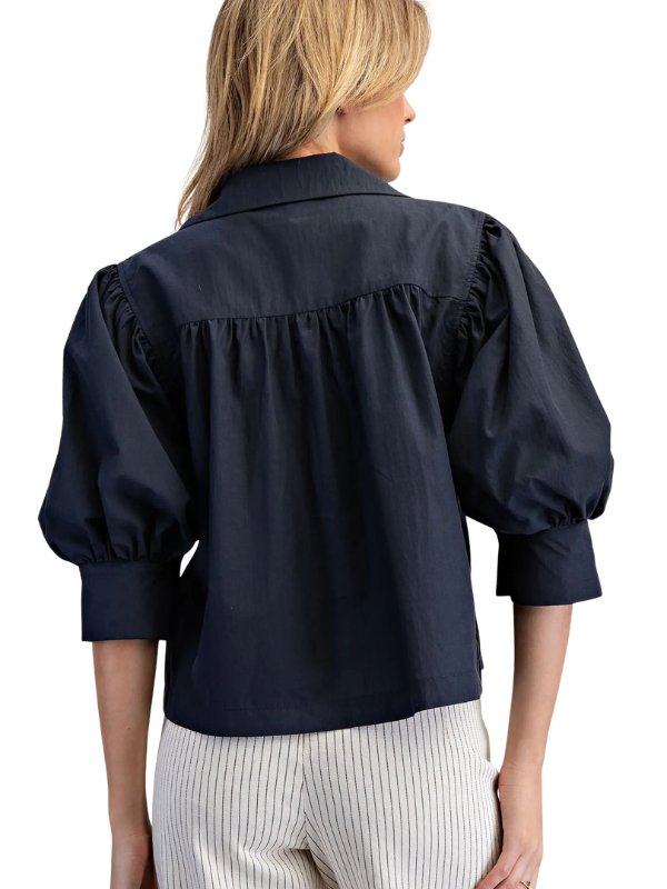 woman wearing navy puff sleeve top 