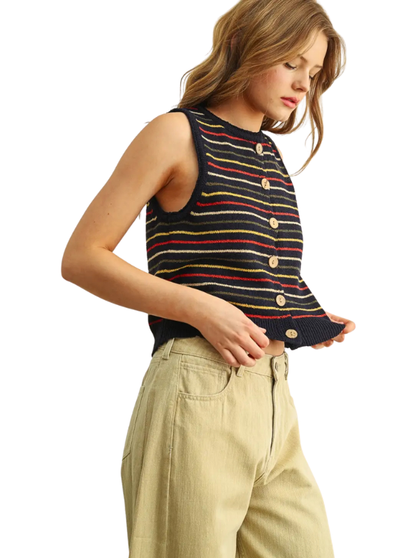 A woman wearing a sleeveless knit top with horizontal stripes in navy, red, yellow, and white, paired with beige pants, shown against a plain white background.