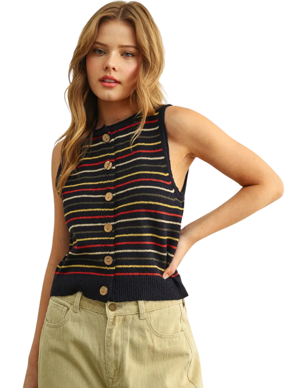 A woman wearing a sleeveless knit top with horizontal stripes in black, red, yellow, and white, featuring a button-up front, paired with khaki pants, against a plain white background.
