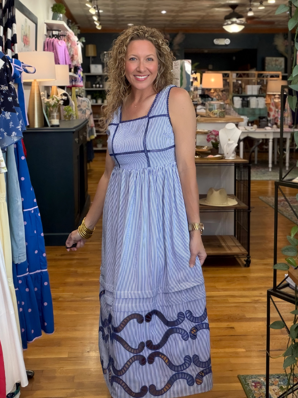 Woman wearing a blue patterned dress in a store setting