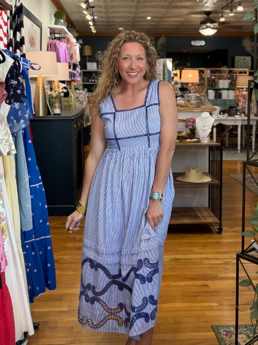 Woman in a blue dress standing in a clothing store