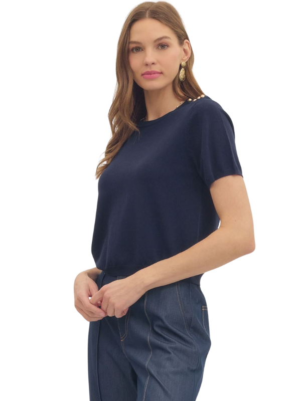 Woman wearing a navy blue t-shirt and jeans on a white background