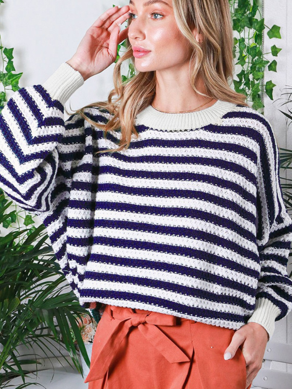 Woman wearing a striped sweater with plants in the background