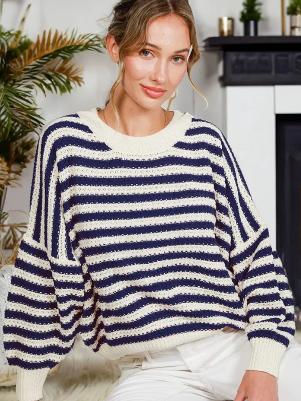 Woman wearing a navy and white striped sweater in a home setting.