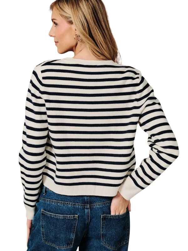 A woman shown from the back wearing a cropped long-sleeve knit sweater with horizontal black and off-white stripes, paired with blue jeans, against a plain white background.