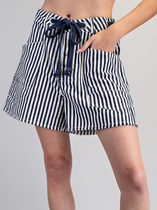 Black and white striped shorts with a drawstring on a gray background