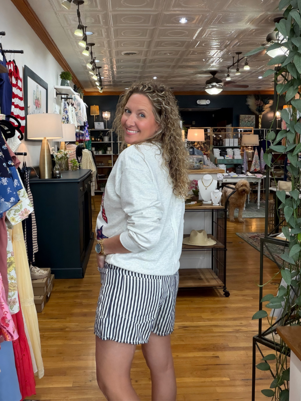 Woman standing in a store with clothing and decor around her