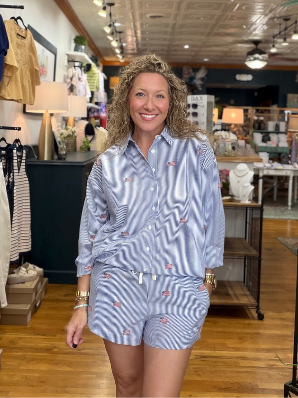 Woman wearing a blue striped shirt and shorts in a store setting