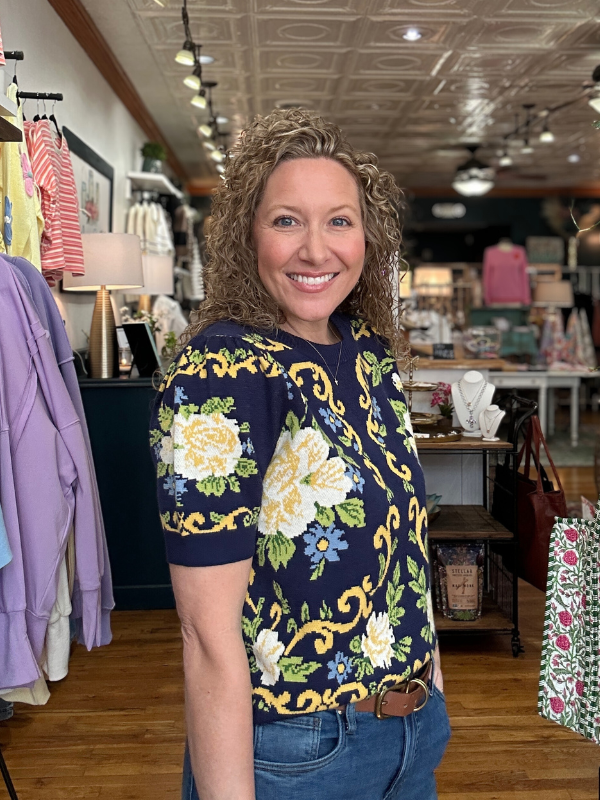 Woman wearing a floral top in a store setting