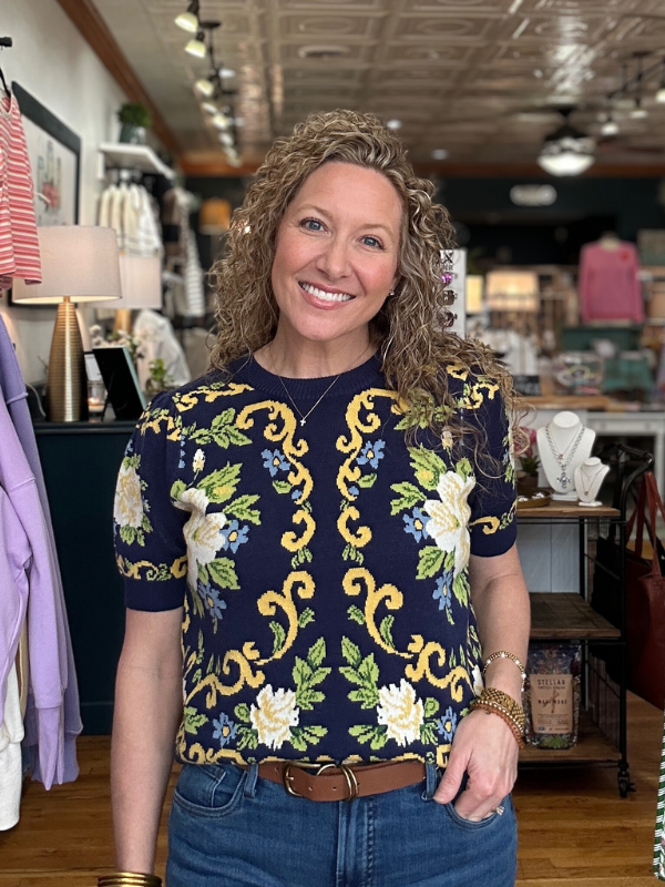 Woman wearing a navy blue floral-patterned shirt in a store setting