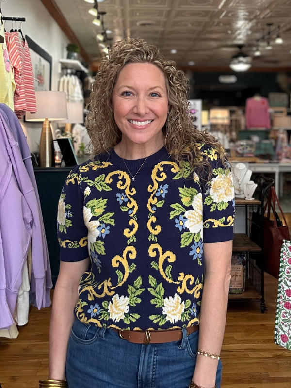 Woman wearing a floral patterned top in a store setting