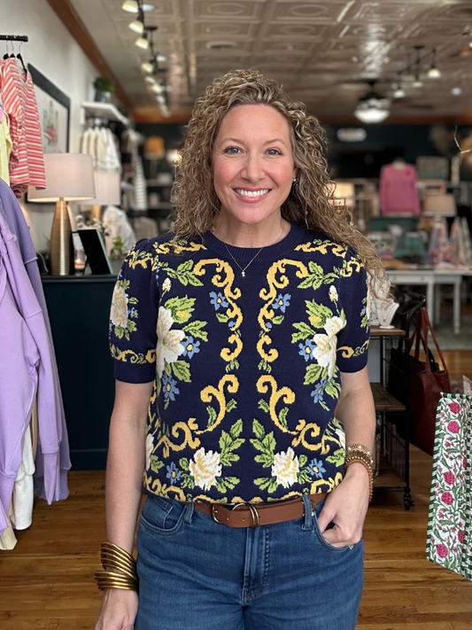 Woman wearing a patterned shirt in a store setting