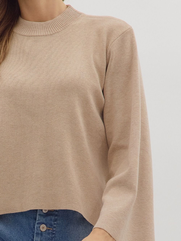 Beige sweater worn by a person on a plain background