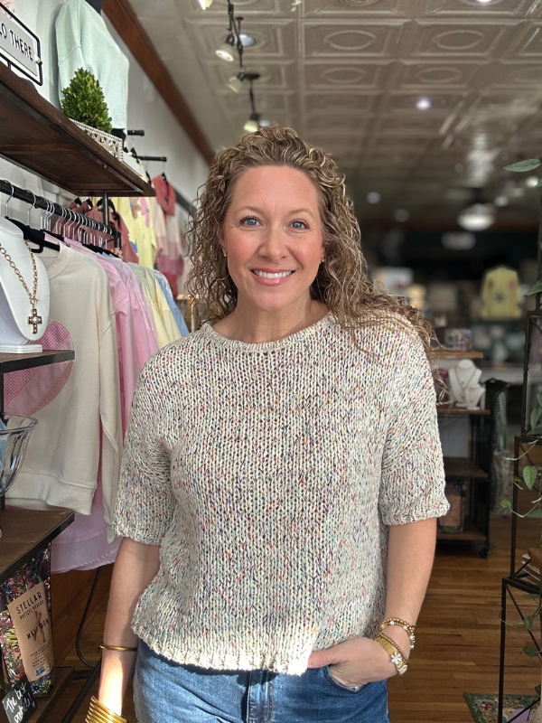 Woman wearing a patterned sweater in a store setting