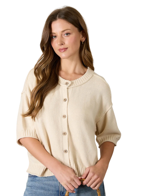 Woman wearing a beige cardigan over a white background