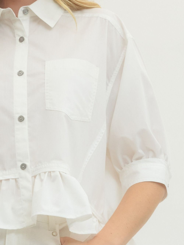 White blouse with ruffled details on a plain background