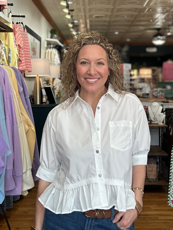 Woman wearing a white blouse in a store setting