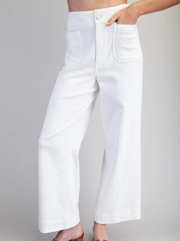 White wide-leg jeans worn by a person on a gray background
