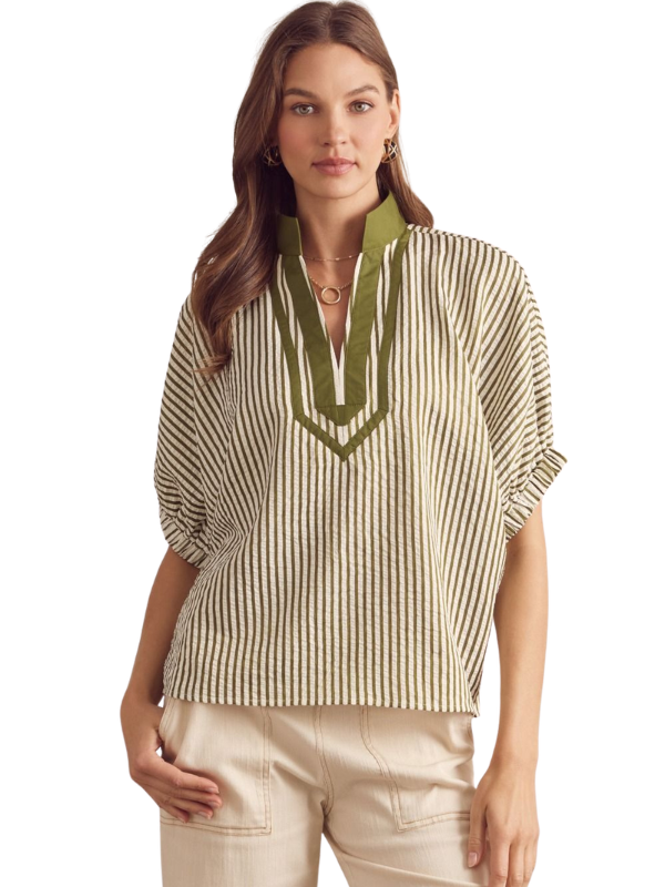 Woman wearing a striped blouse with green accents on a white background