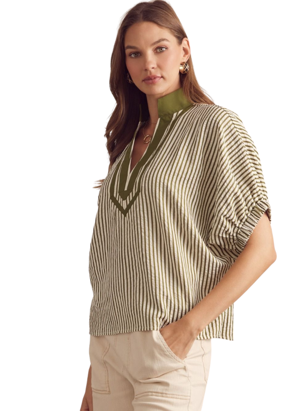 Woman wearing a striped blouse with a green collar on a white background