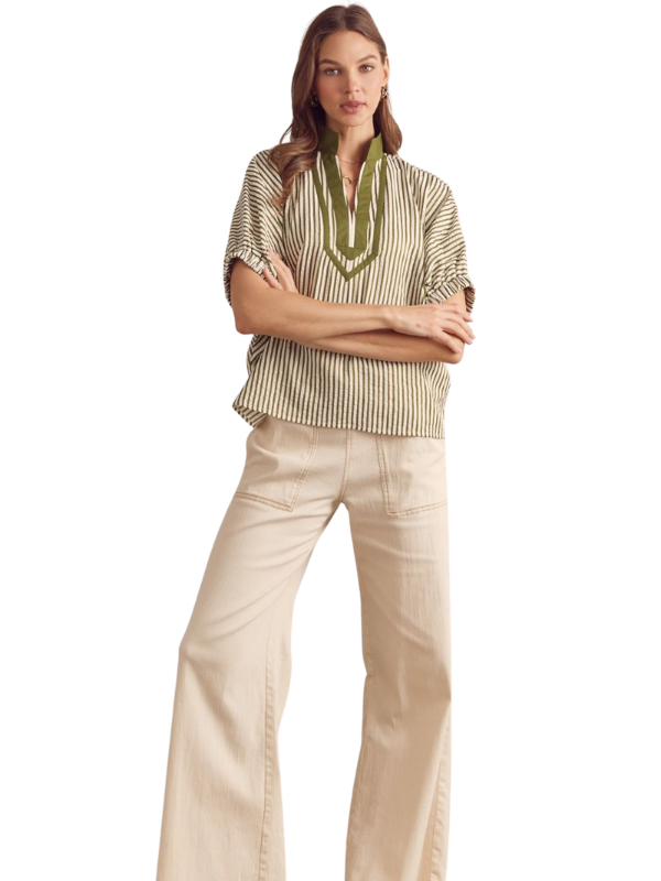 Woman wearing a striped shirt and beige pants on a white background