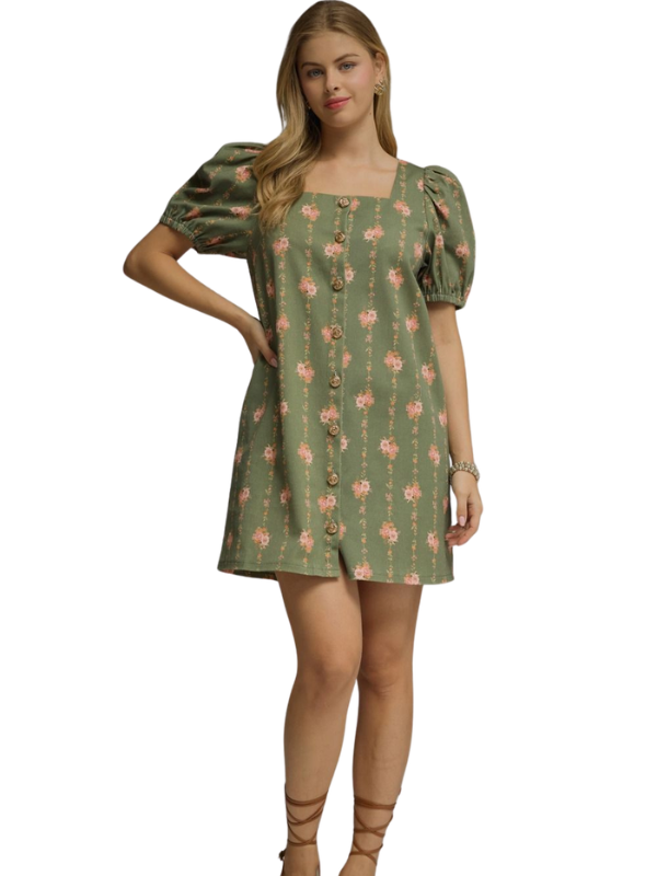 Woman wearing a green dress with pink floral pattern on a white background