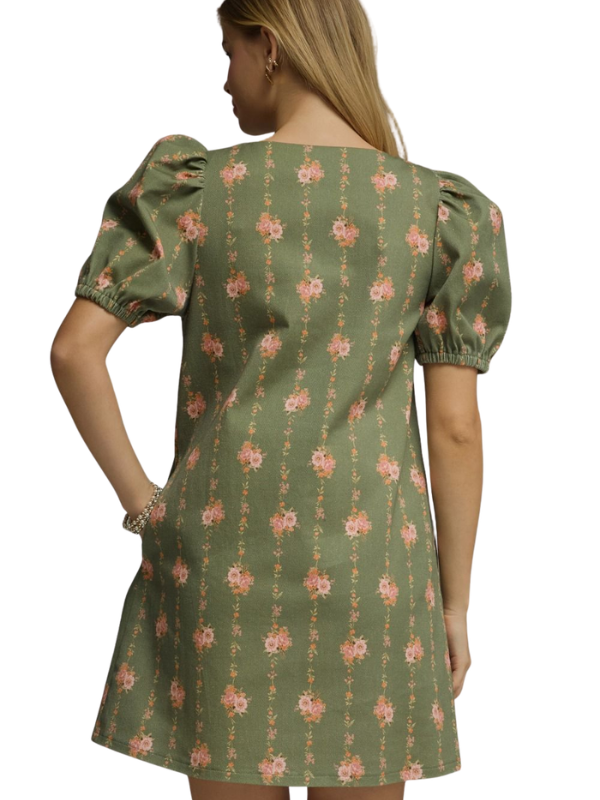 Green floral dress worn by a person on a white background