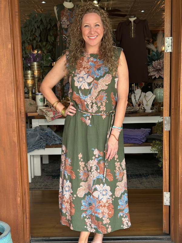 Woman wearing a floral dress standing in a store.