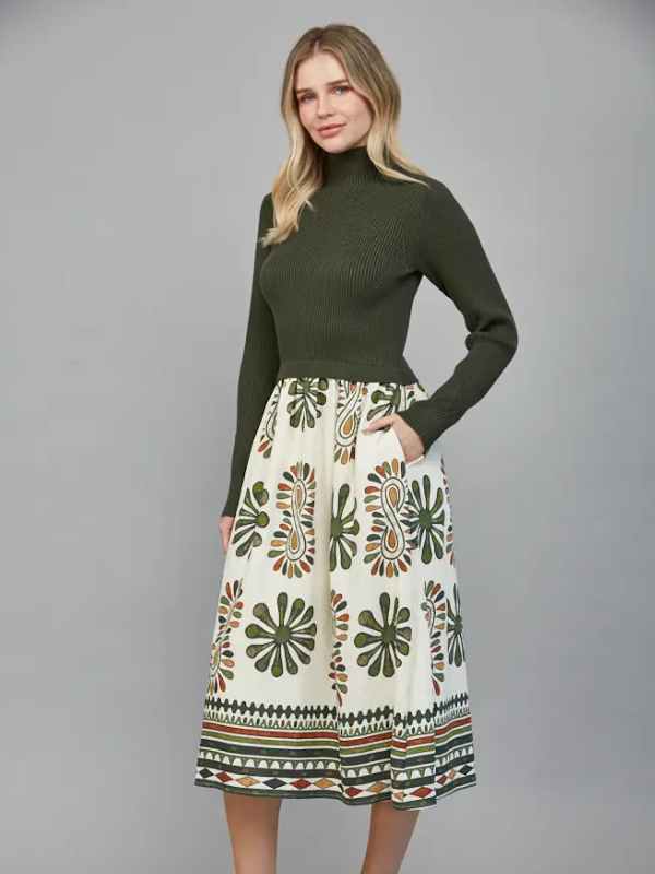 Woman wearing a green sweater and patterned skirt on a gray background