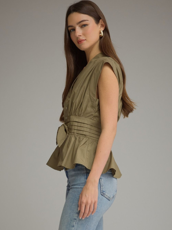 woman wearing an olive sleeveless top and jeans