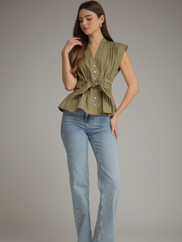 woman wearing an olive sleeveless top and jeans