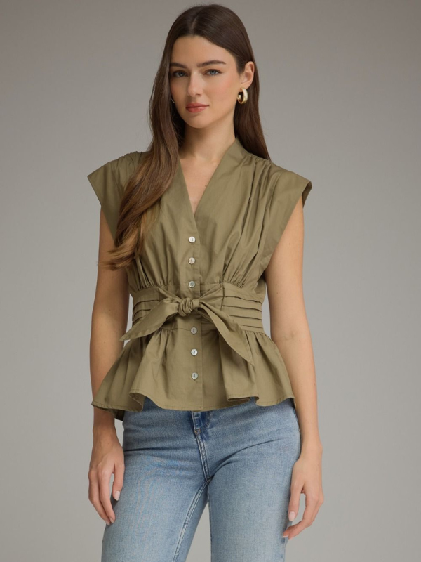 woman wearing an olive sleeveless top and jeans