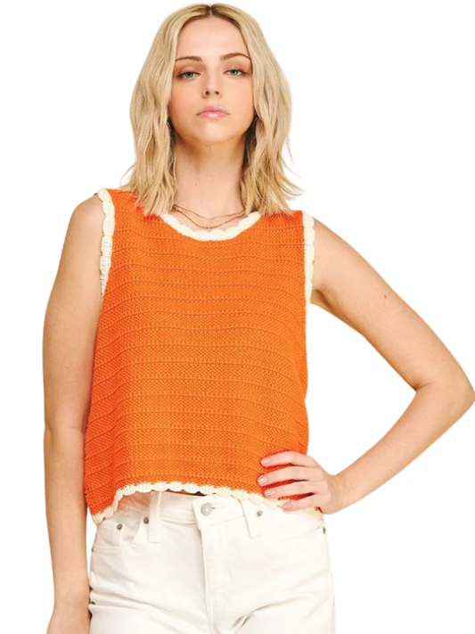 Woman wearing an orange sleeveless top with a white background