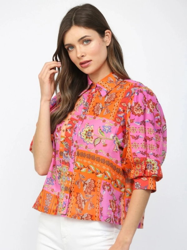 Woman wearing a colorful patterned blouse on a white background