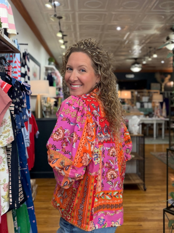 Woman wearing a colorful floral jacket in a store setting