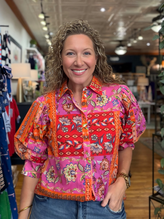 Woman wearing a colorful patterned shirt in a store setting