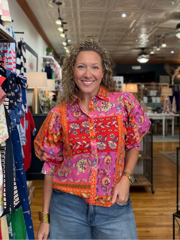 Woman wearing a colorful patterned shirt in a store setting