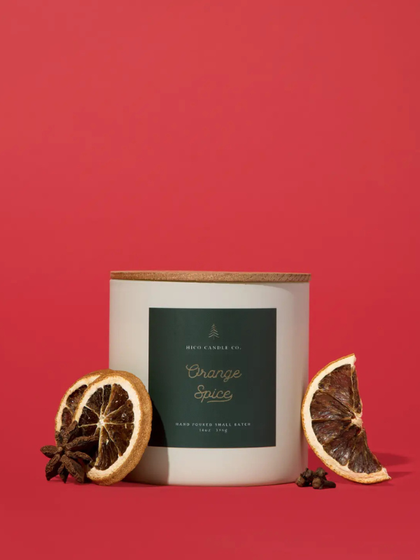 Candle labeled 'Orange Spice' with dried oranges and star anise on a red background