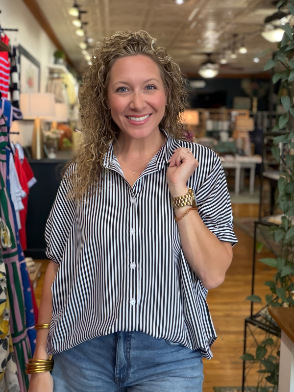 Woman wearing a striped shirt and jeans in a store setting