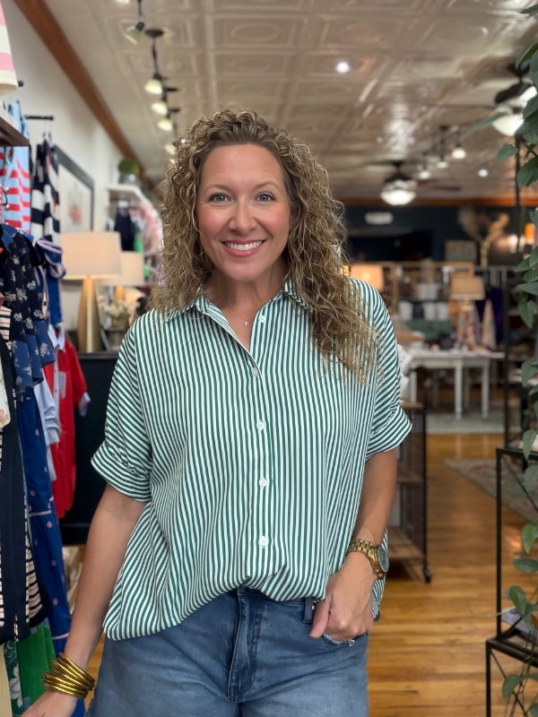 Woman wearing a green and white striped shirt in a store setting