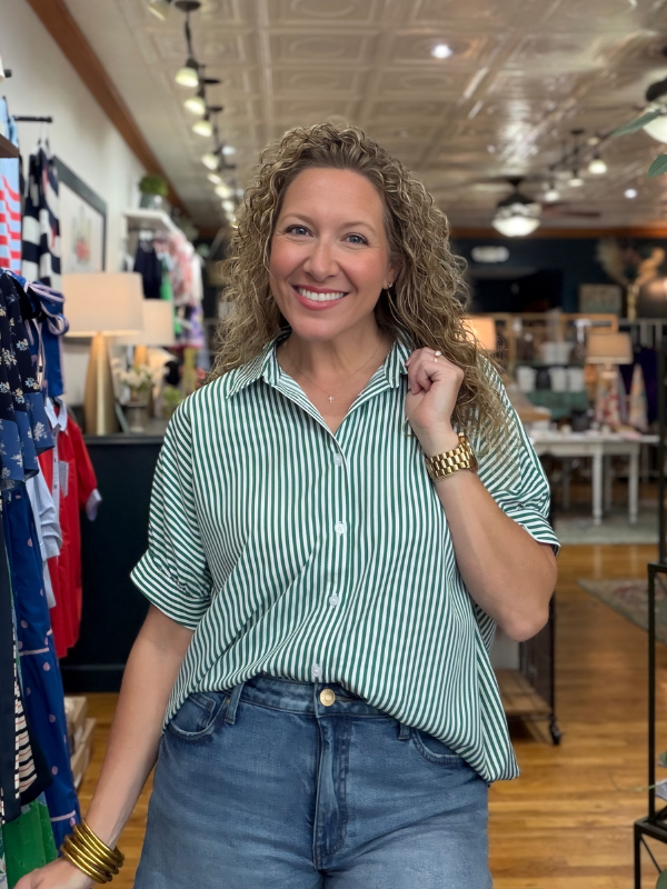 Woman in a striped shirt and jeans standing in a store.