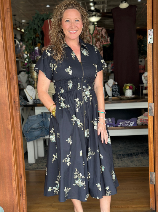 Woman wearing a navy floral dress in a store setting