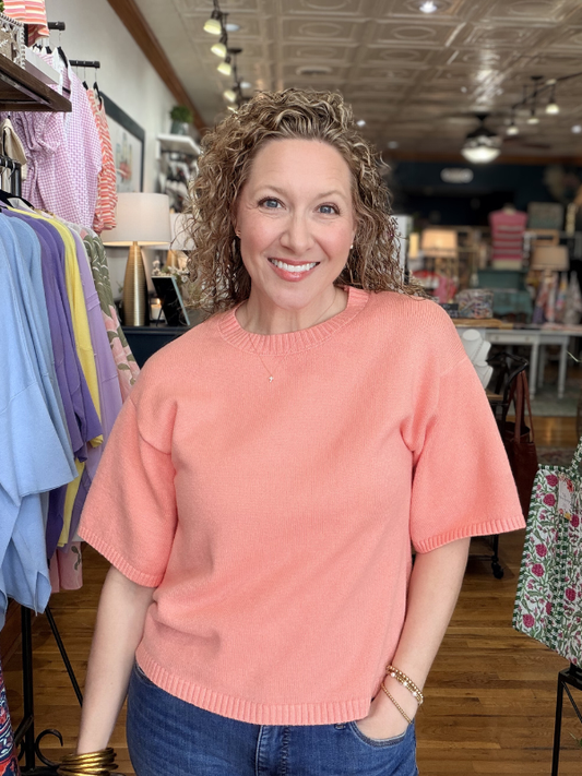 Woman wearing a pink sweater in a clothing store