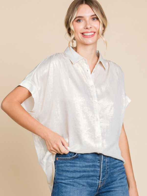 Woman wearing a white short-sleeve blouse and blue jeans on a beige background